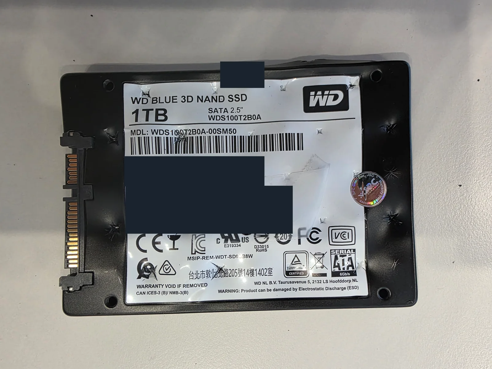 천공 파쇄 작업 후 WD Blue WDS100T2B0A SSD 뒷면, 일련번호와 WWN 가림